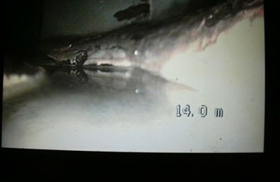 Beeld van de rioolcamera: kalkafzetting op de wand van een leiding op 14,0 meter