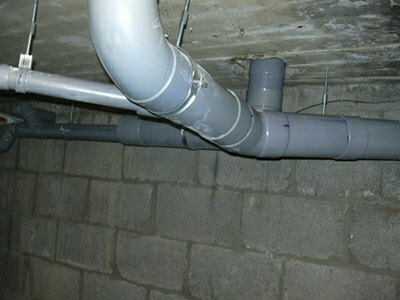 Nieuwe pvc-leidingen met bochten onder het plafond