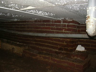 Doorgezakte leiding in de kruipruimte, van dichtbij